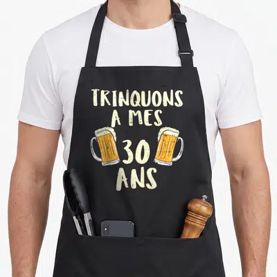 Tablier de cuisine noir avec l'inscription Trinquons à mes 30 ans et deux verres de bière illustrés.