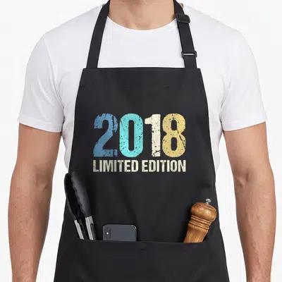 Tablier de cuisine noir avec l'inscription 2018 Limited Edition en lettres colorées et effet vieilli.
