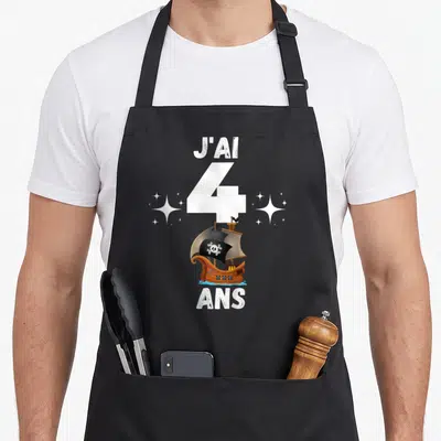 Tablier de cuisine noir avec un navire pirate, le chiffre 4 et les mots J'ai 4 ans entourés d'étoiles.