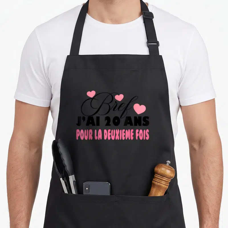 Tablier de cuisine noir avec inscription « Bref j'ai 20 ans pour la deuxième fois » et cœurs roses, design d'anniversaire.
