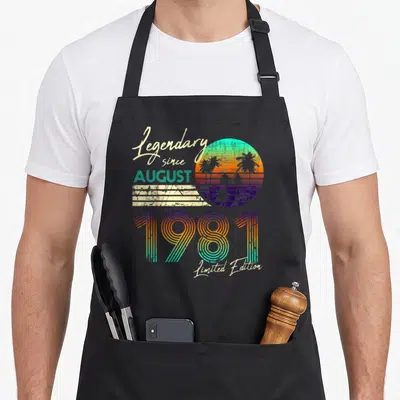 Tablier de cuisine noir avec illustration rétro 1981, palmiers et texte Limited Edition coloré.