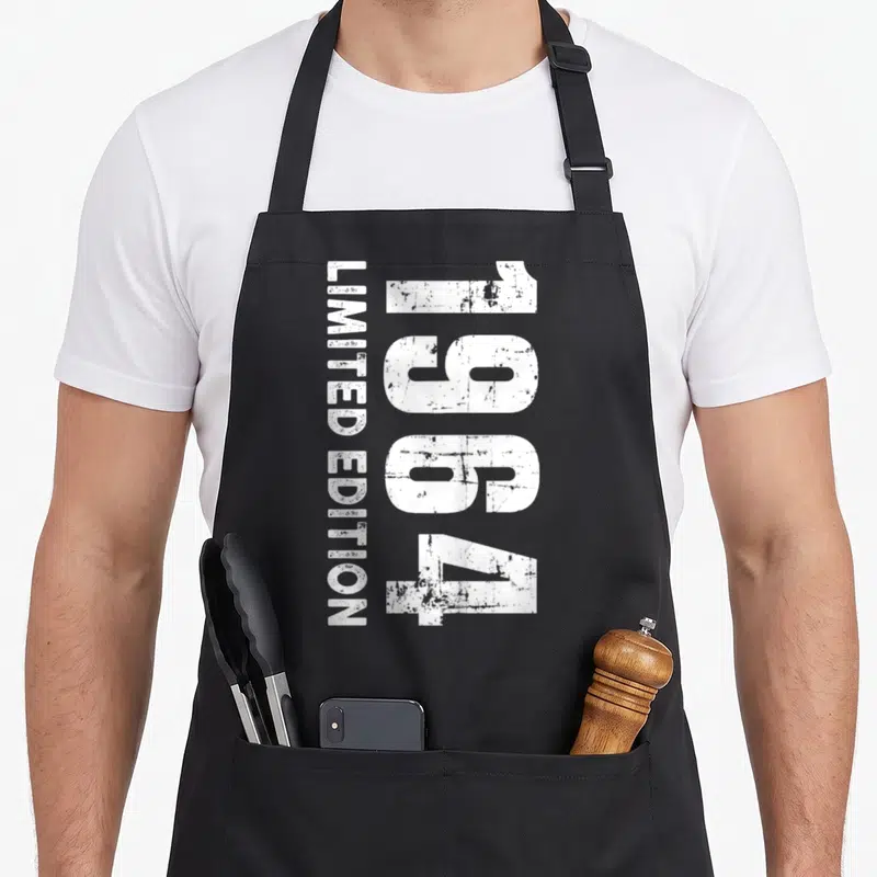 Tablier de cuisine noir avec inscription 1964 édition limited edition en blanc effet usé.