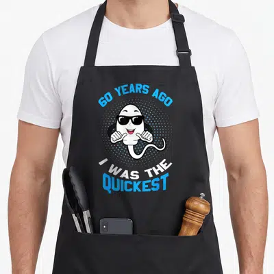 Tablier de cuisine noir avec illustration d'un spermatozoïde aux lunettes de soleil et texte 60 years ago I was the quickest