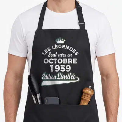 Tablier de cuisine noir avec inscription blanche Les Légendes Sont Nées en Octobre 1959 surmontée d'une couronne stylisée.