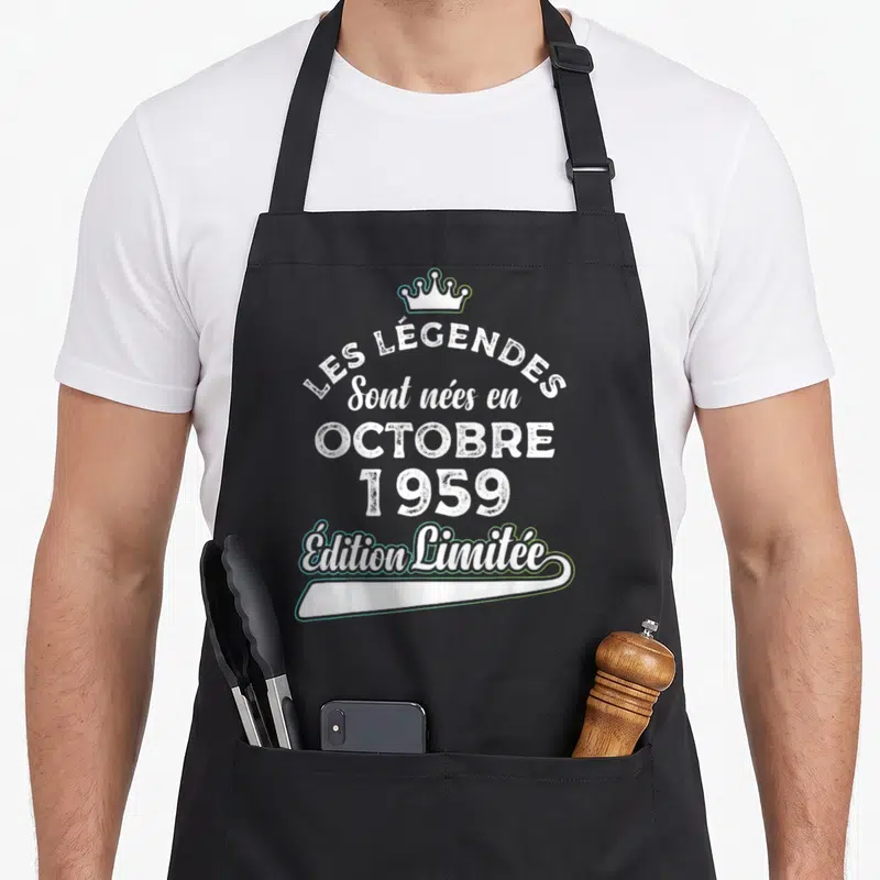 Tablier de cuisine noir avec inscription blanche Les Légendes Sont Nées en Octobre 1959 surmontée d'une couronne stylisée.