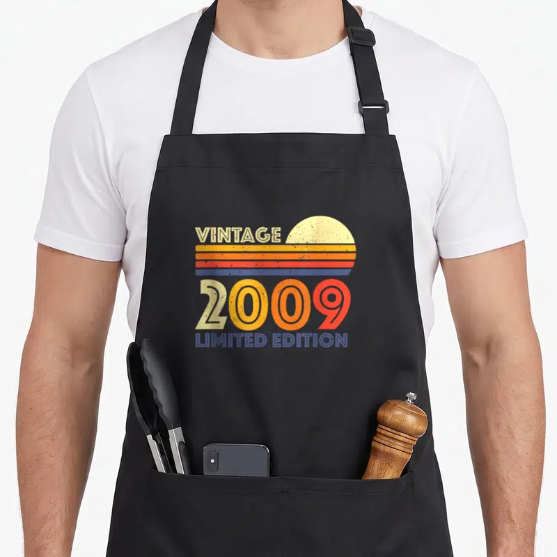 Tablier de cuisine noir avec motif rétro 2009 Vintage Limited Edition et soleil couchant aux couleurs chaudes.