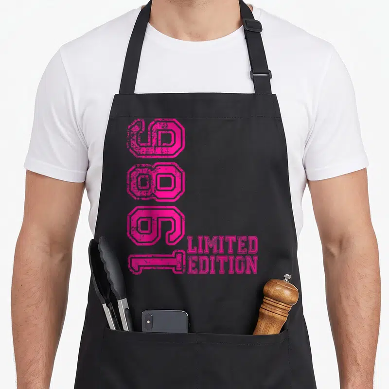 Tablier de cuisine noir avec l'année 1986 et Limited Edition en rose vif stylisé verticalement.