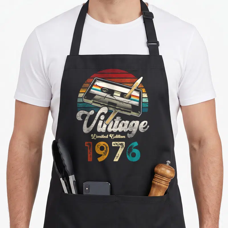 Tablier de cuisine noir avec illustration cassette audio vintage 1976 Limited Edition et crayon coloré.