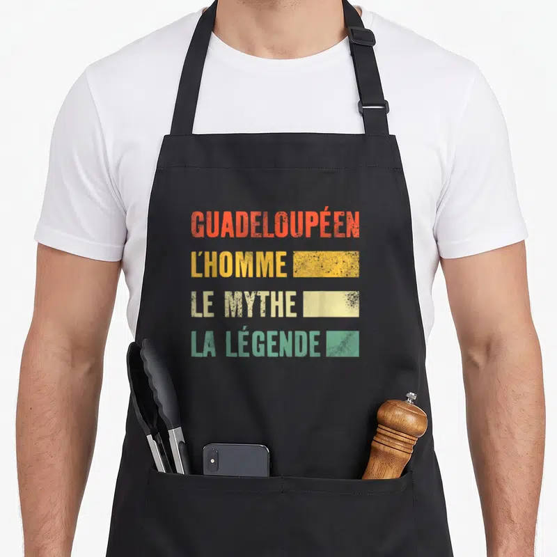 Tablier de cuisine noir avec texte Guadeloupéen L'Homme Le Mythe La Légende en couleurs dégradées.