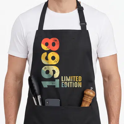Tablier de cuisine noir avec les chiffres 1968 verticaux et Limited Edition en typographie rétro multicolore.