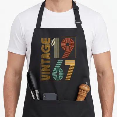 Tablier de cuisine noir avec motif graphique vintage 1967 aux couleurs chaudes et lignes géométriques rétro.