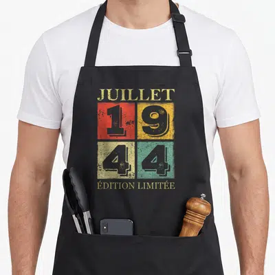 Tablier de cuisine noir avec motif vintage Juillet 1944 et « Édition Limitée » sur fond quadricolore.