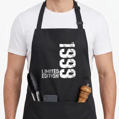 Tablier de cuisine noir avec inscription verticale 1999 etLimited Edition en blanc style délavé.