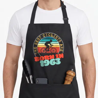 Tablier de cuisine noir avec motif vintage cycliste et texte né en 1963 coloré.