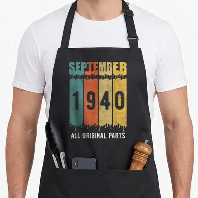 Tablier de cuisine noir avec bandes colorées vert orange jaune et texte vintage gris blanc.