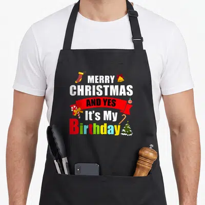 Tablier de cuisine noir avec inscription Joyeux Noël et yes its my anniversaire coloré et décorations de fêtes.