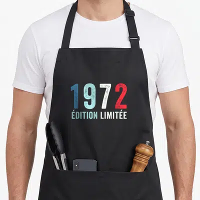 Tablier de cuisine noir avec l'année 1972 et « Édition Limitée » en typographie vintage multicolore.