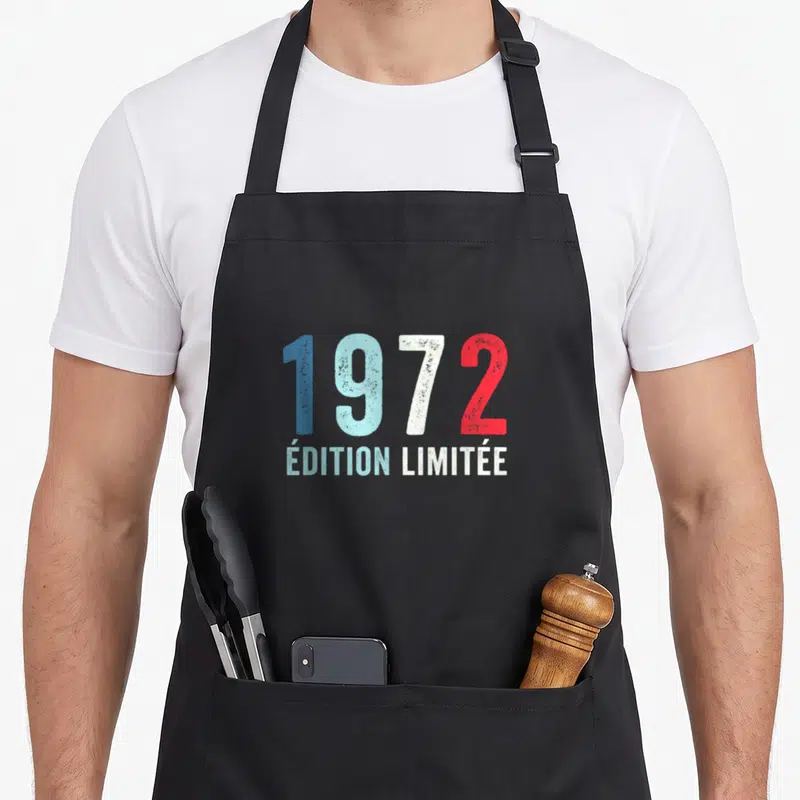 Tablier de cuisine noir avec l'année 1972 et « Édition Limitée » en typographie vintage multicolore.