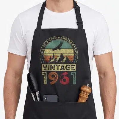 Tablier de cuisine noir avec motif vintage 1961, aigle en vol, montagnes et inscription « édition limitée ».