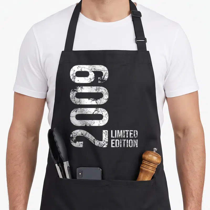 Tablier de cuisine noir avec l'année 2009 imprimée verticalement en blanc et la mention Limited Edition à côté.