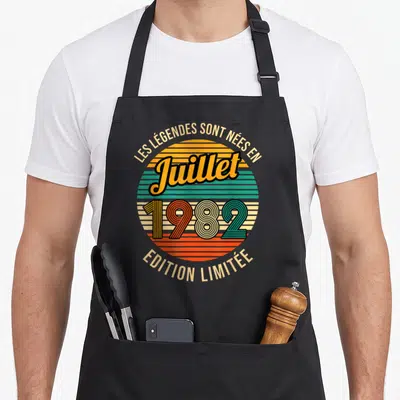 Tablier de cuisine noir avec motif circulaire vintage coloré et texte Les Légendes sont nées en Juillet 1982 « Édition Limitée »