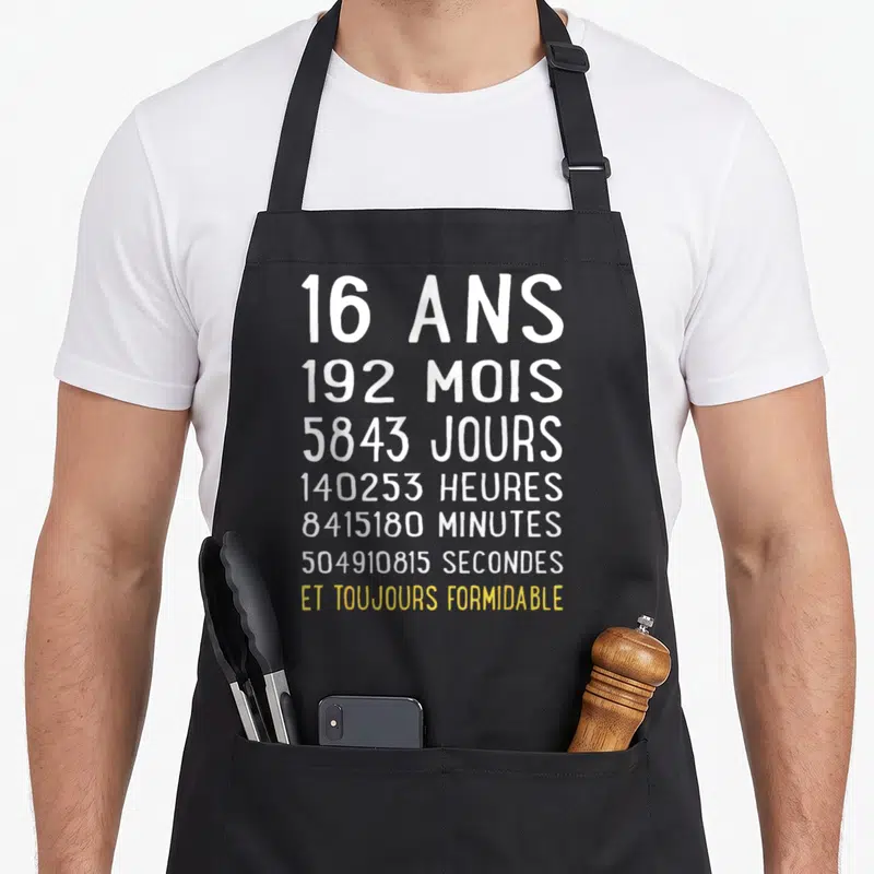 Tablier de cuisine noir avec inscription blanche 16 ans 192 mois et toujours formidable en jaune.