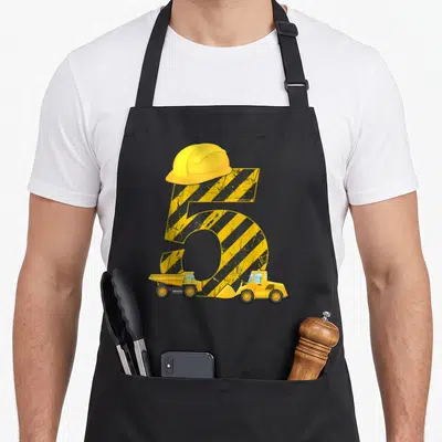 Tablier de cuisine noir avec un chiffre 5 jaune et noir surmonté d'un casque, accompagné d'un excavateur et d'un camion benne.