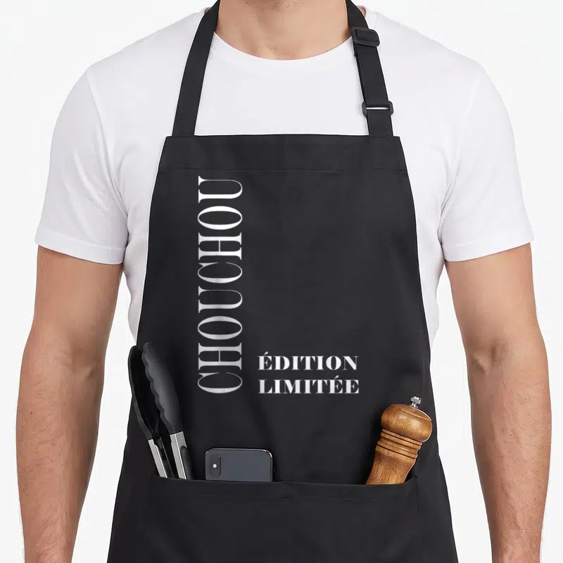 Tablier de cuisine noir avec le mot Chouchou écrit verticalement en grandes lettres blanches et « Édition Limitée » en bas à droite.