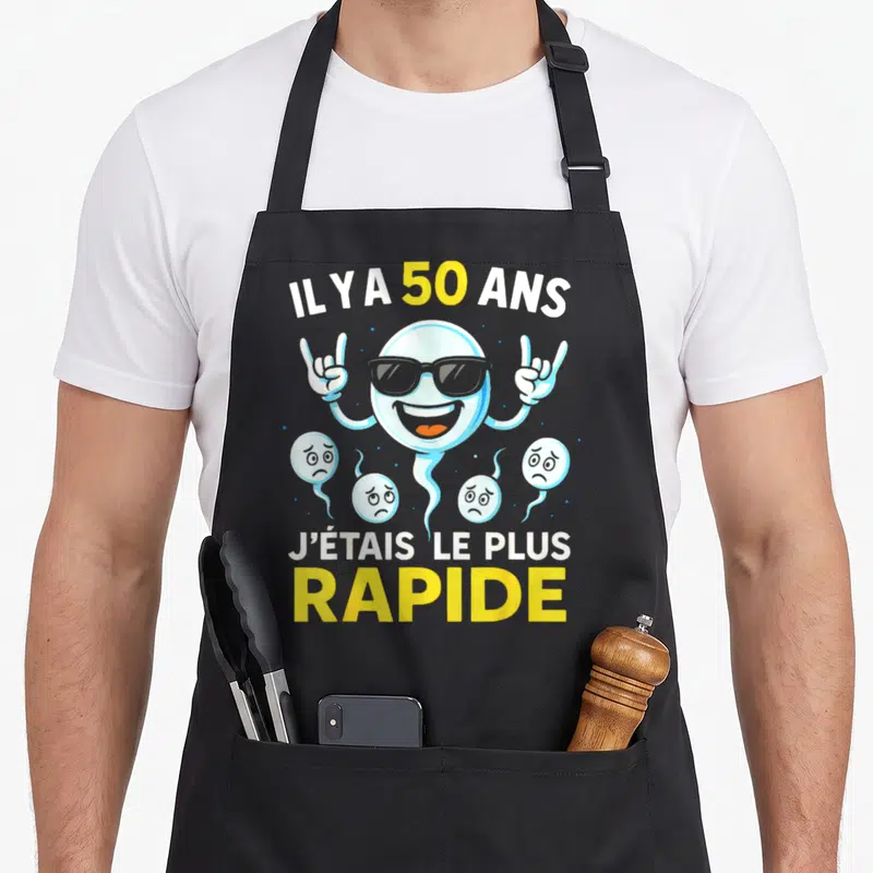 Tablier de cuisine noir avec un ballon souriant aux lunettes noires et le texte Il y a 50 ans j'étais le plus rapide.