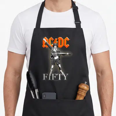 Tablier de cuisine noir avec illustration d'un guitariste en noir et blanc, logo orange au-dessus et texte blanc en bas.
