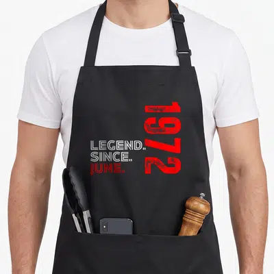 Tablier de cuisine noir avec inscription légende since juin 1972 en rouge et blanc sur fond gris uni.
