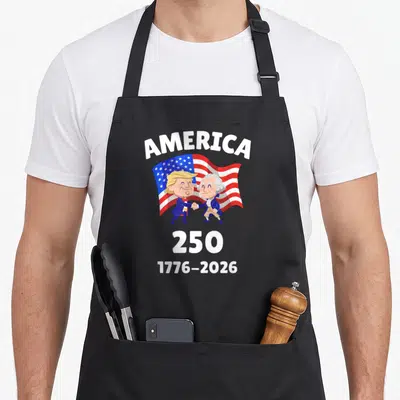 Tablier de cuisine noir avec illustration caricaturale de Trump et Washington se serrant la main sous le mot America et les dates 250 1776-2026.