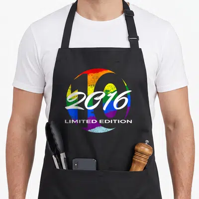 Tablier de cuisine noir avec motif circulaire arc-en-ciel affichant 2016 Limited Edition et le chiffre 10 stylisé.