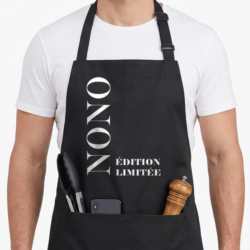 Tablier de cuisine noir avec le prénom Nono écrit verticalement en blanc et « Édition Limitée » en bas à droite.