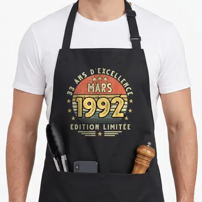 Tablier de cuisine noir avec motif circulaire retro 33 ans d'excellence mars 1992 edition limitée et étoiles dorées.