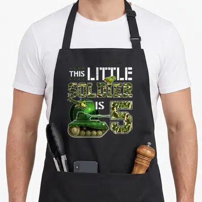 Tablier de cuisine noir avec illustration militaire tank hélicoptère et texte This Little Soldier Is 5 Boys en camouflage.