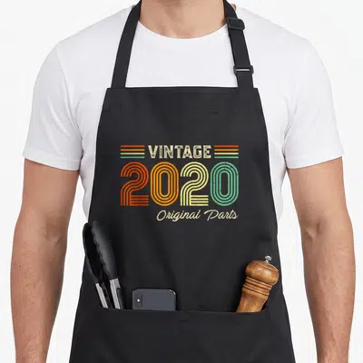 Tablier de cuisine noir avec inscription Vintage 2020 Original Parts en lettres rétro multicolores.