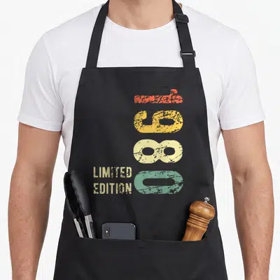 Tablier de cuisine noir avec inscription 1980 Limited Edition et chiffres colorés style vintage délavé.