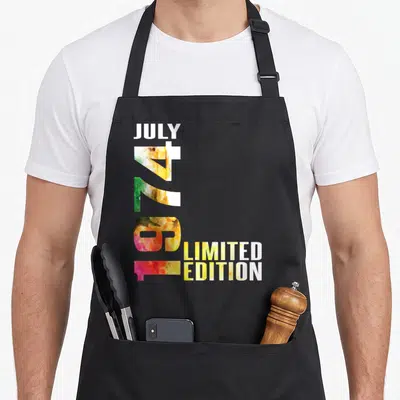 Tablier de cuisine noir avec typographie verticale colorée juillet 1974 limited edition en aquarelle.