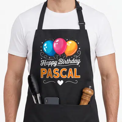 Tablier de cuisine noir avec trois ballons colorés et le nom Pascal en lettres orange vives.