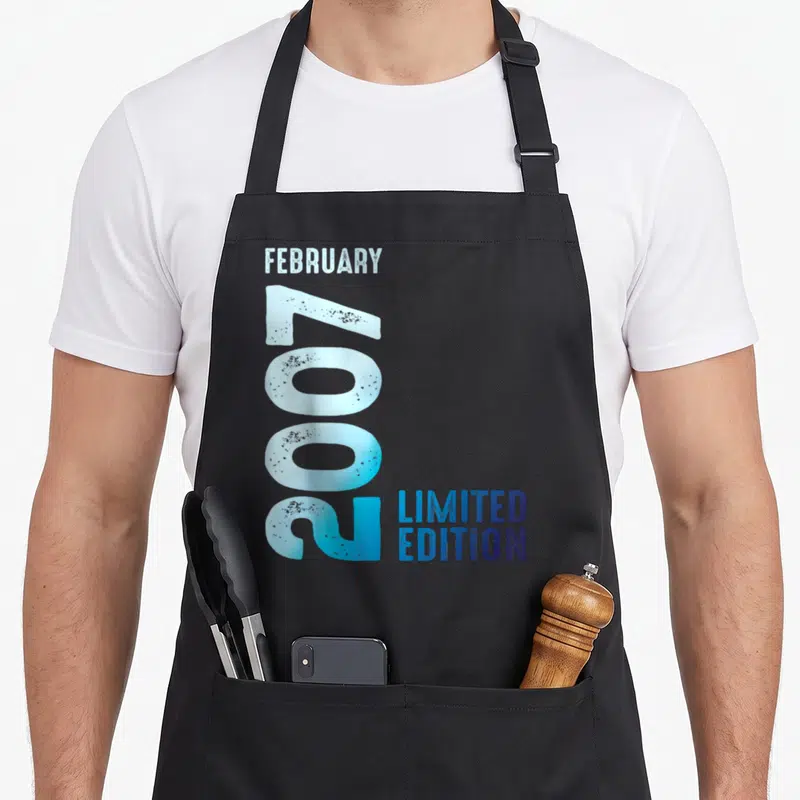 Tablier de cuisine noir avec l'inscription February 2007 Limited Edition en typographie bleue et blanche.