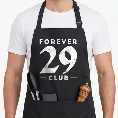 Tablier de cuisine noir avec inscription blanche Forever 29 Club au style vintage et texturé.