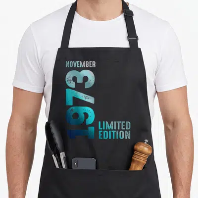 Tablier de cuisine noir avec inscription verticale Novembre 376 1973 Limited Edition en dégradé bleu cyan et blanc cassé.