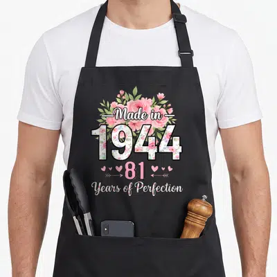 Tablier de cuisine noir avec inscription « Made in 1944 », 81 et Years of Perfection entouré de roses roses.
