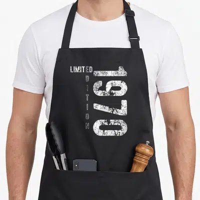 Tablier de cuisine noir avec linscription 1970 en grand et Limited Edition verticalement à côté.