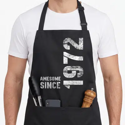 Tablier de cuisine noir avec inscription Génial Depuis 1972 en typographie blanche vintage.