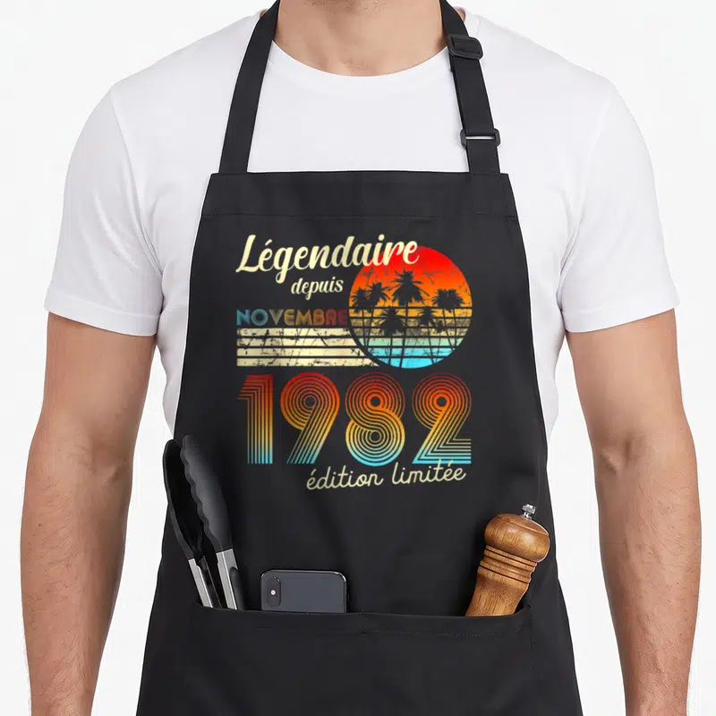 Tablier de cuisine noir avec motif rétro Légendaire depuis Novembre 1982 et soleil orange
