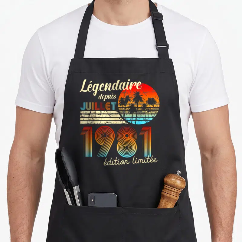 Tablier de cuisine noir avec motif rétro couleur arc-en-ciel et silhouettes de palmiers sur fond de soleil.