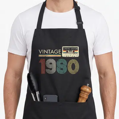 Tablier de cuisine noir avec illustration cassette vintage 1980 Limited Edition et lettrage coloré.