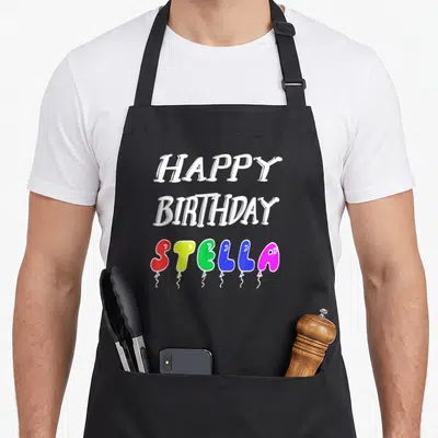 Tablier de cuisine noir avec l'inscription Happy anniversaire Stella formée par des ballons de fête multicolores.